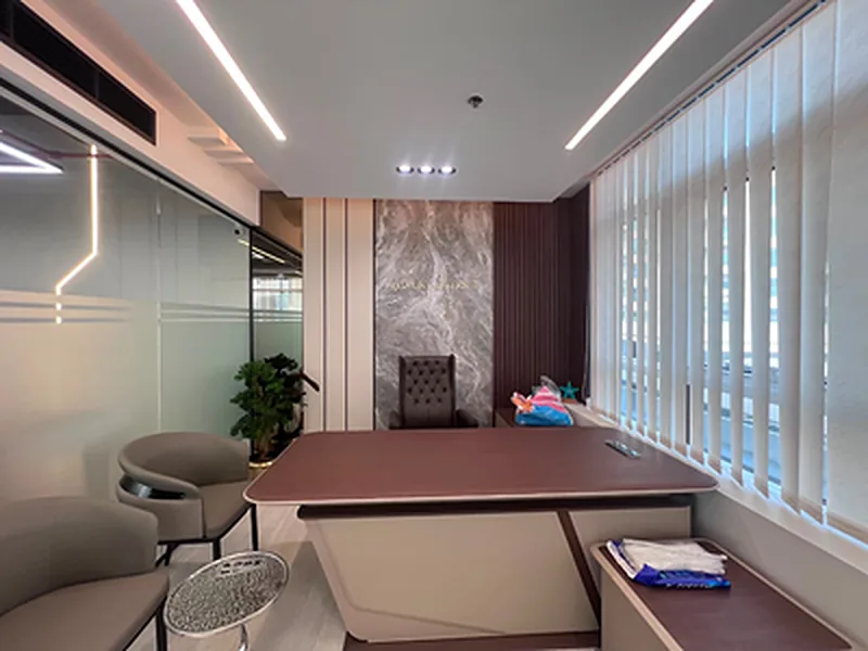 Executive office with timber desk, marble-effect feature wall and glass partition