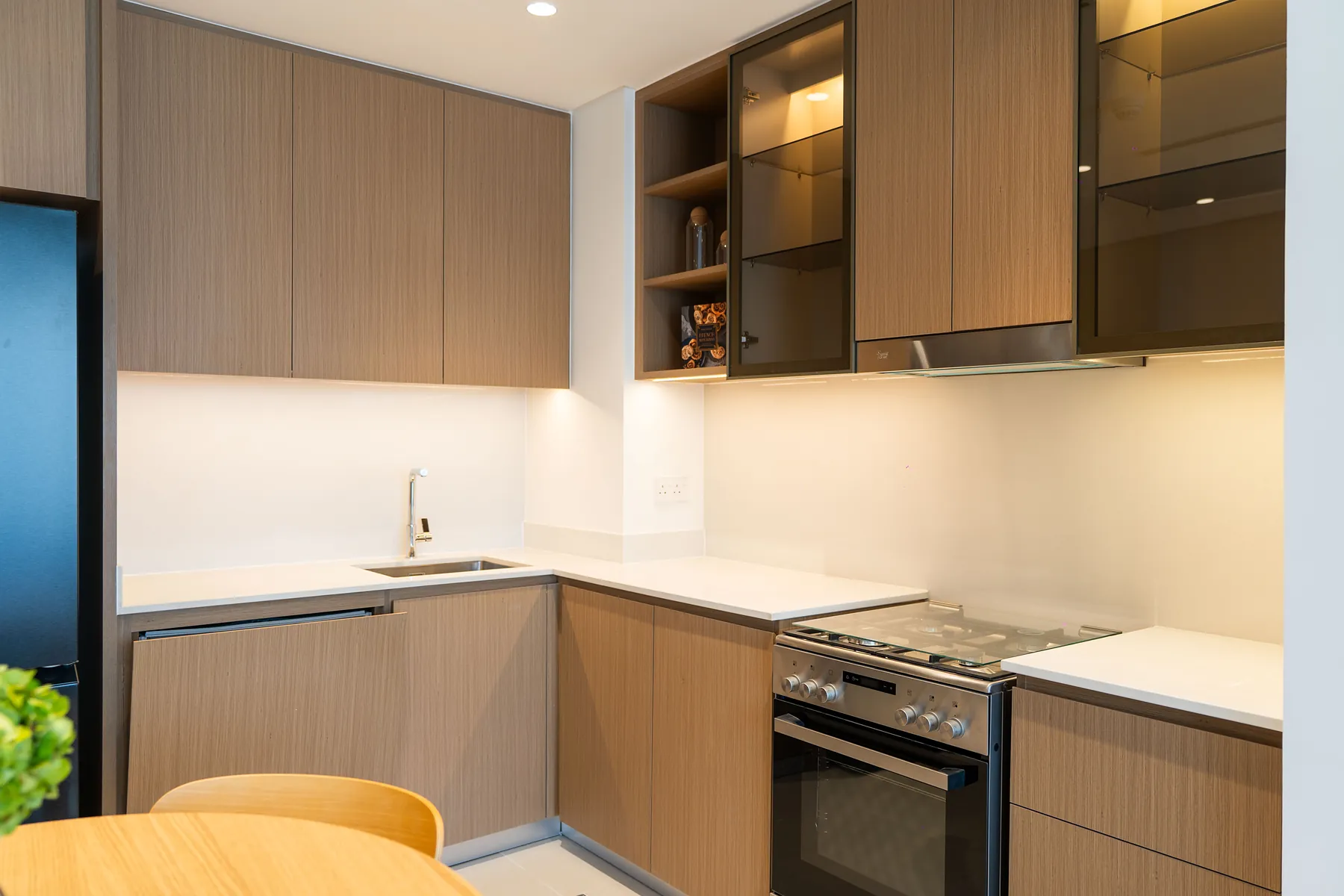 Kitchen with timber cabinets, glass-front wall units, built-in oven and hob