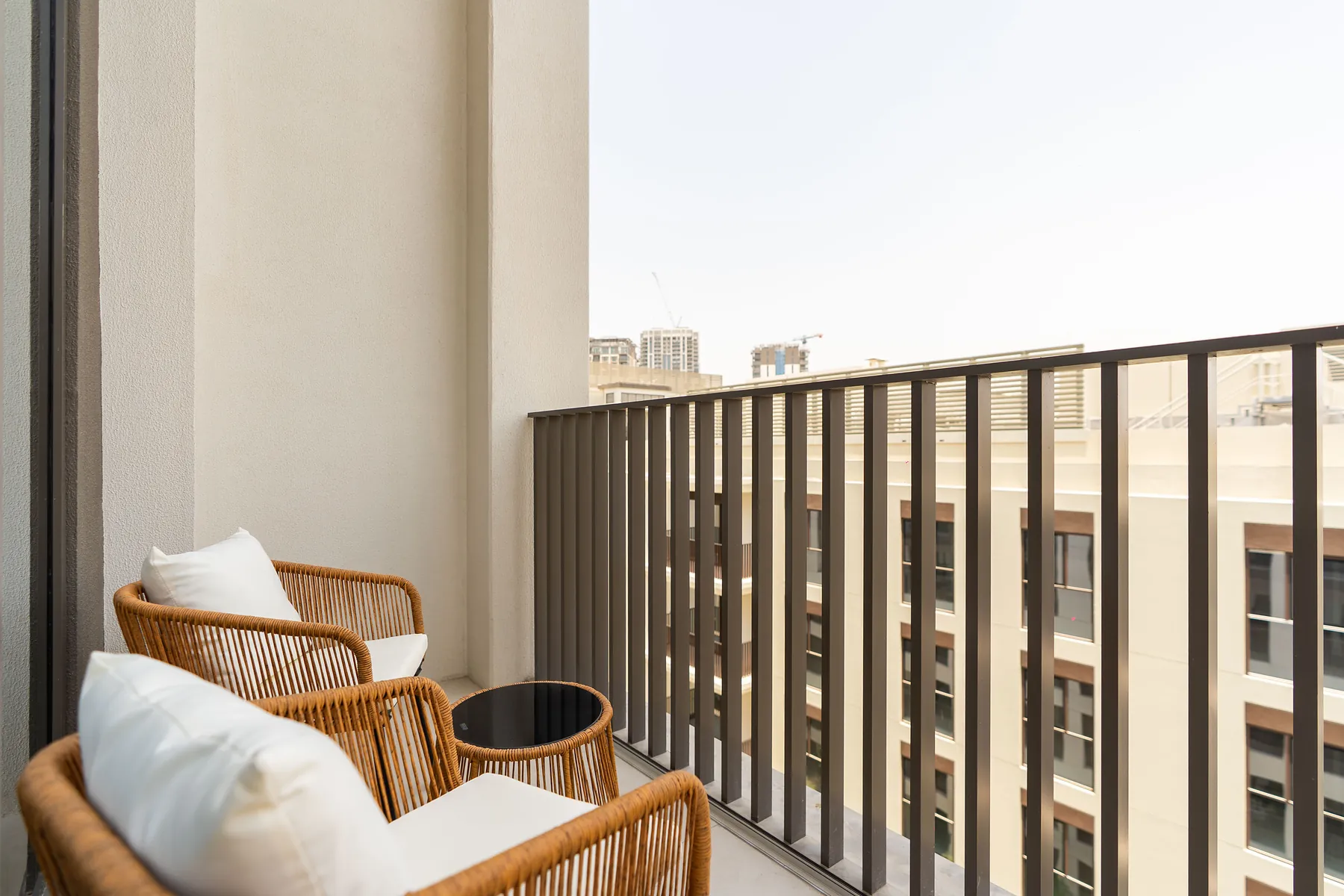 Balcony with rattan lounge chairs and black railings